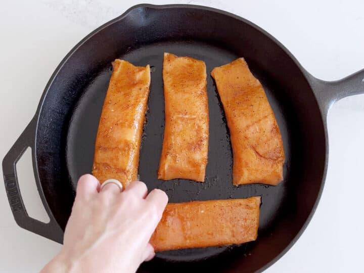 Arranging the seasoned salmon fillets in the pan.