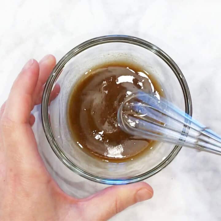 Mixing the dressing in a bowl.