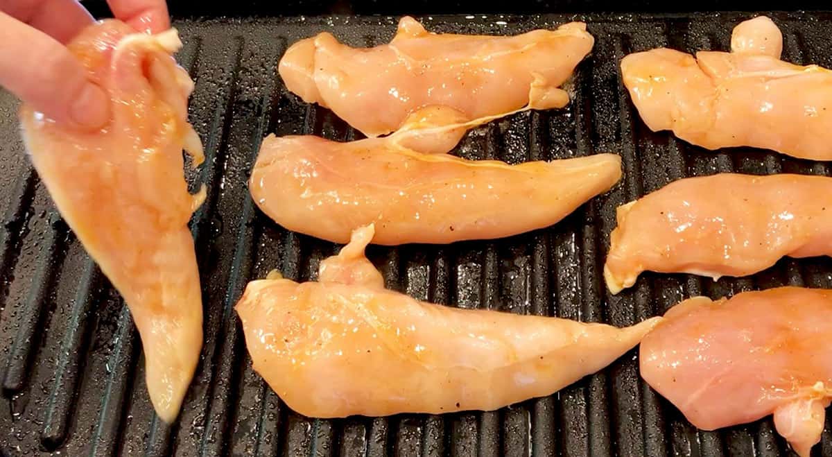 Placing the tenders on the grill.