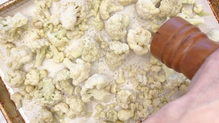 Seasoning the cauliflower with black pepper.