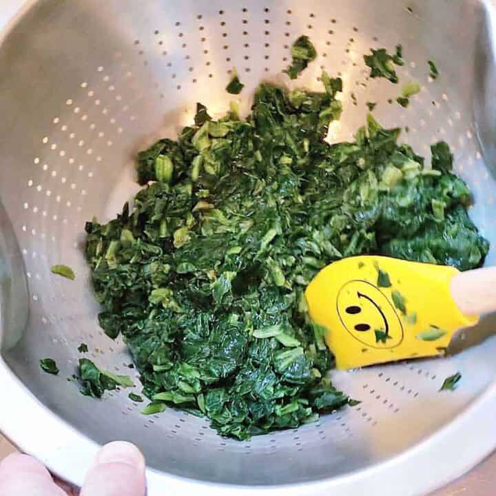 Removing excess water from spinach.