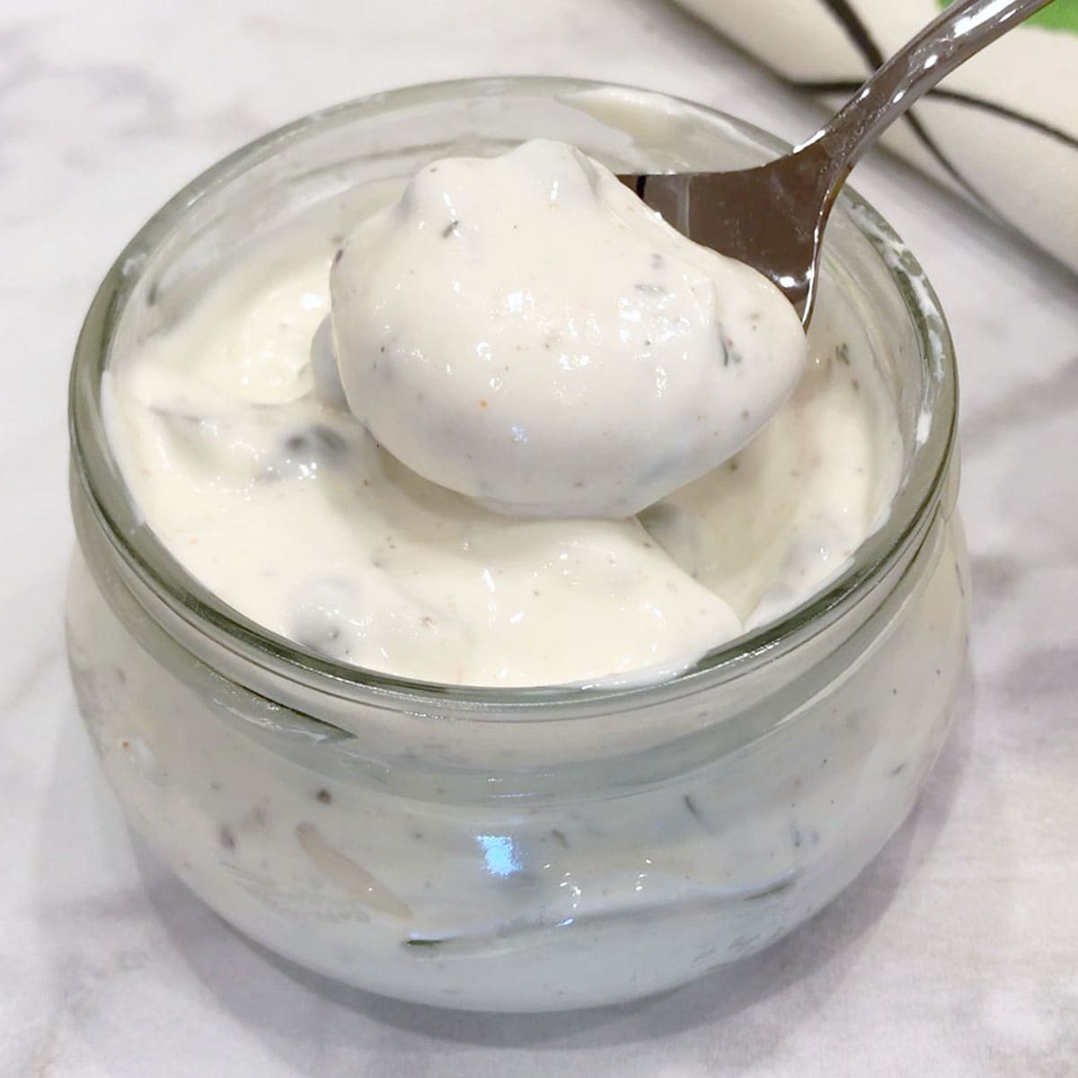 Homemade tartar sauce is served with a spoon.