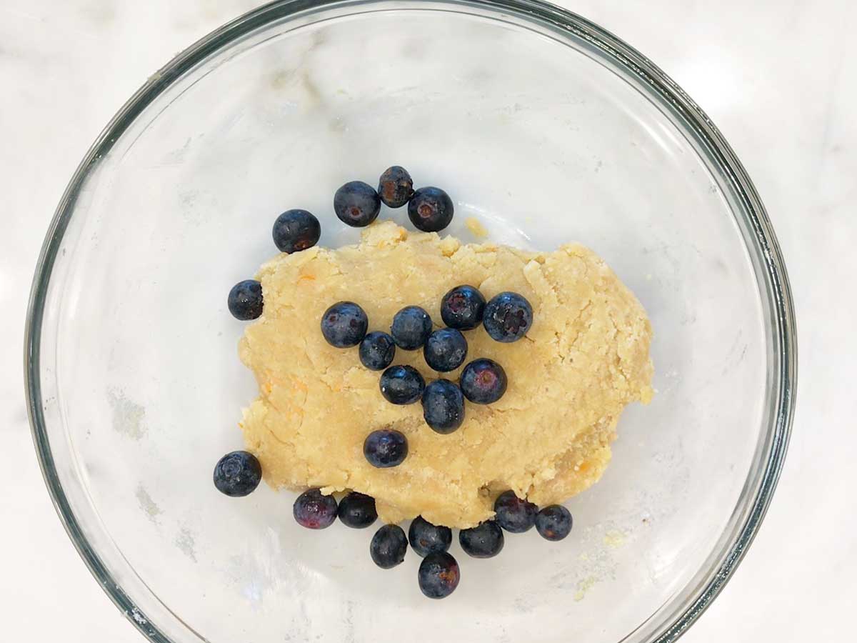 Adding blueberries to the dough.