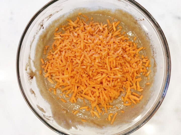 Adding shredded carrots to the batter.