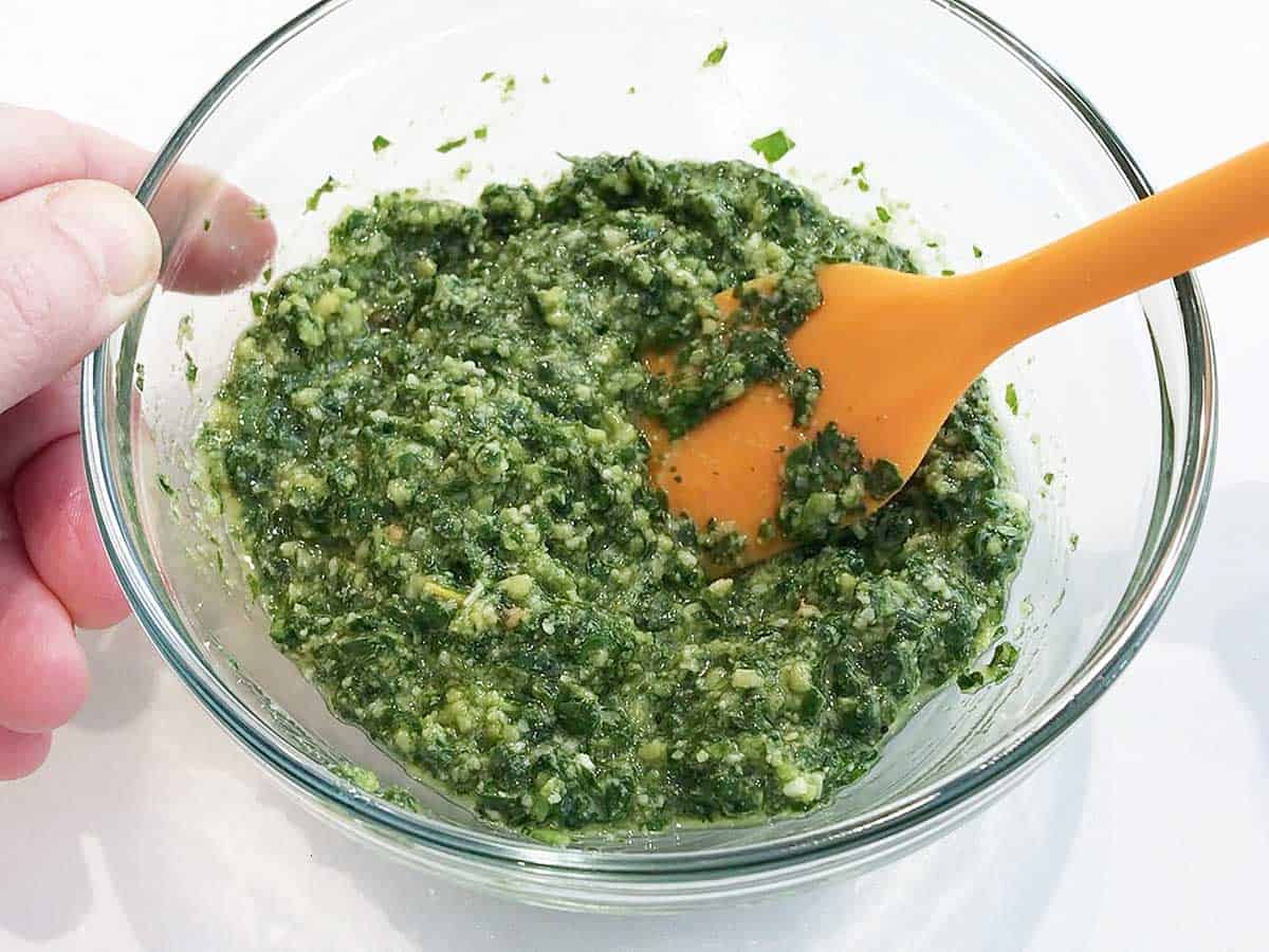 Mixing parmesan into the sauce.