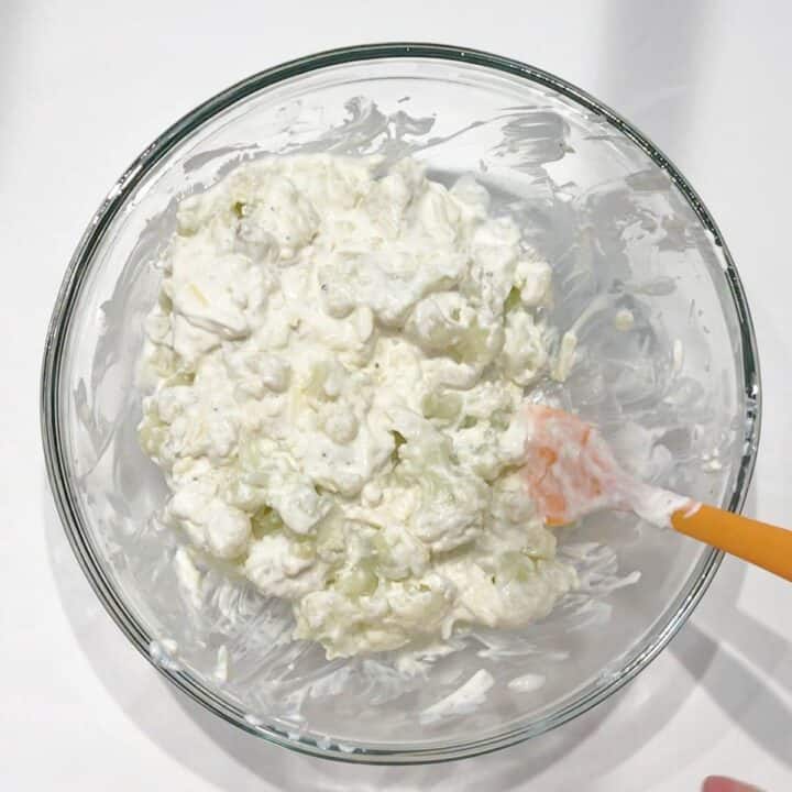 Coating the cauliflower in the sauce.