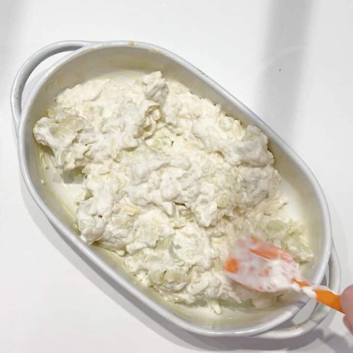 Transferring the gratin mixture to the baking dish.