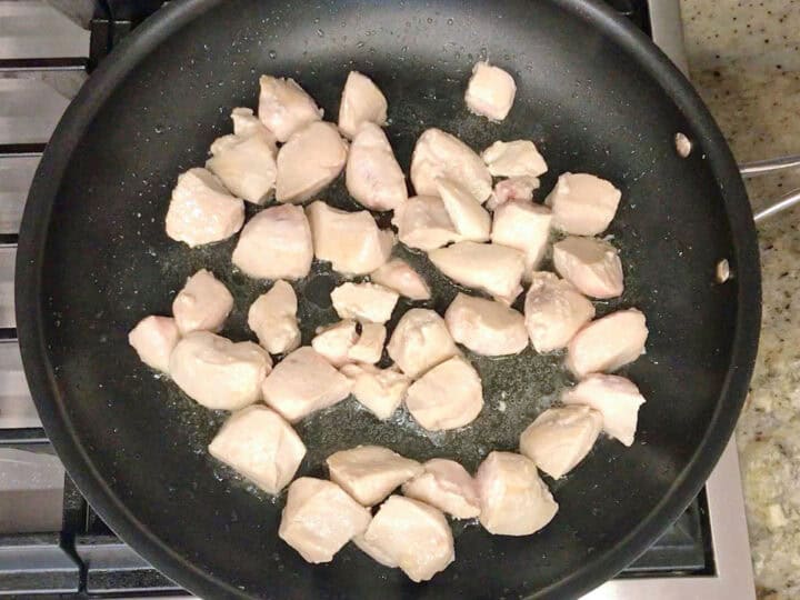 Cooking the chicken in a skillet.