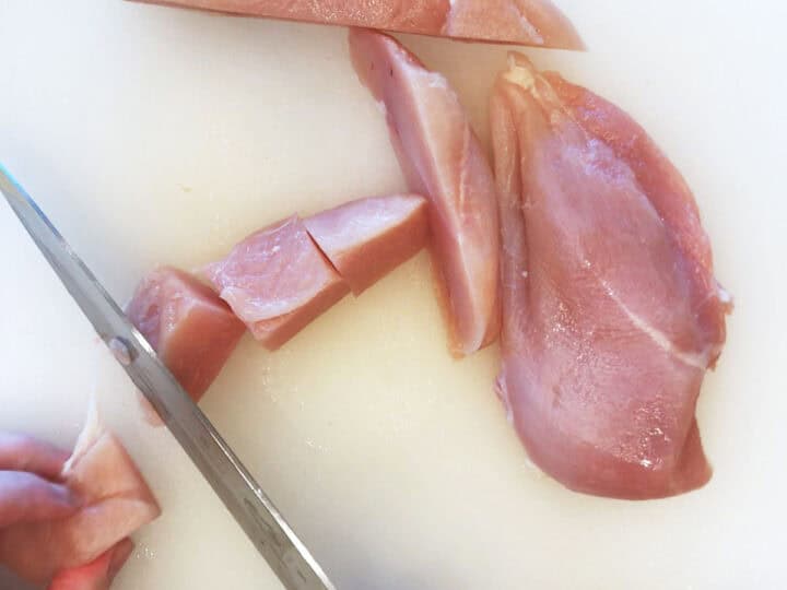 Cutting the chicken into pieces.