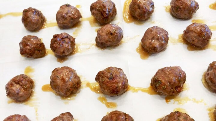 Baked meatballs on a baking sheet.