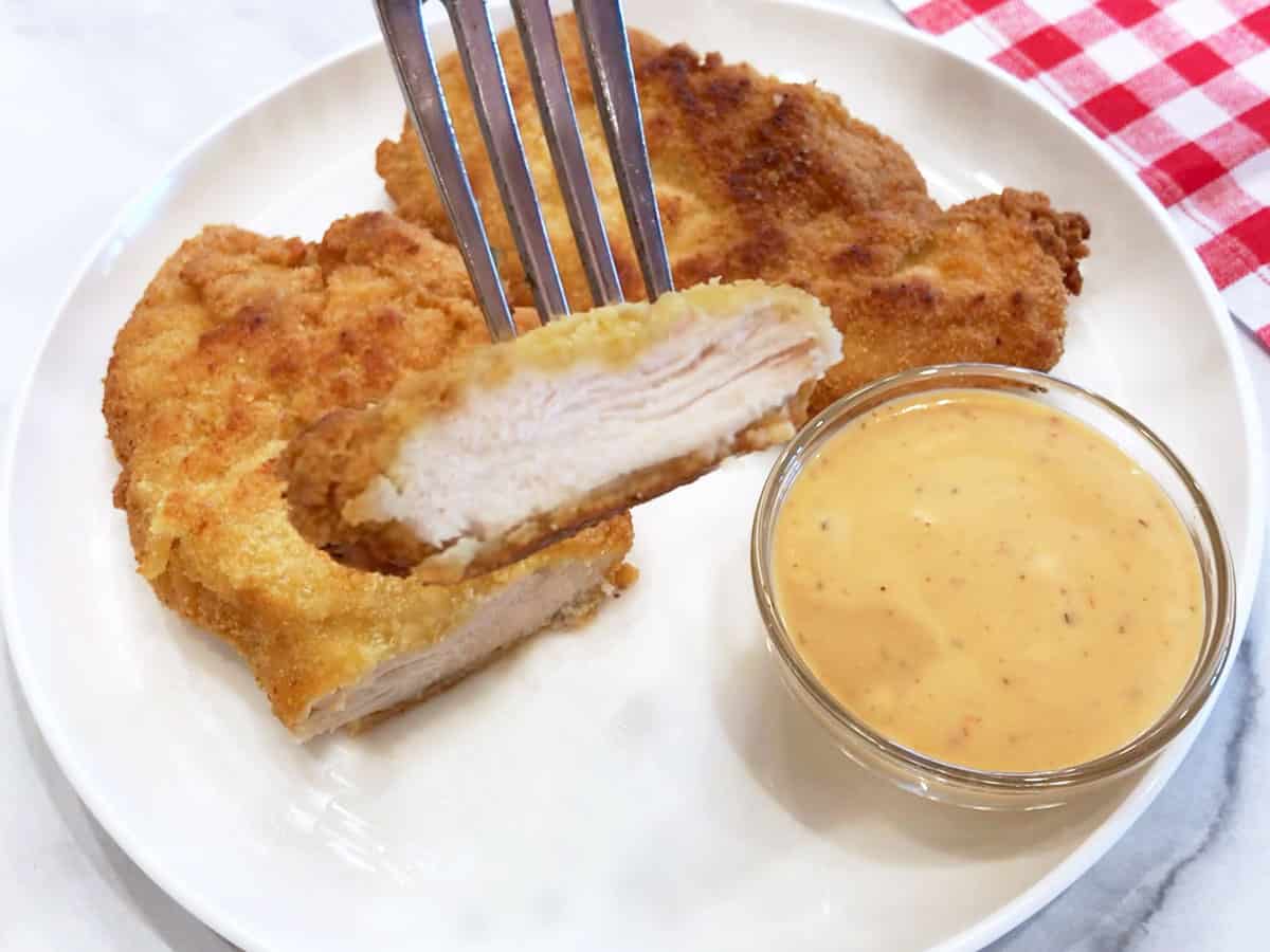 The chicken tenders are served with a dipping sauce.