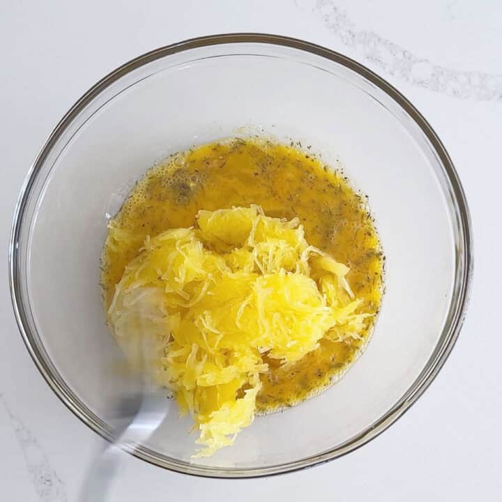 Adding spaghetti squash to the egg mixture.