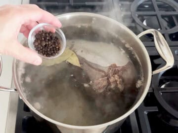 Adding spices to the stockpot.
