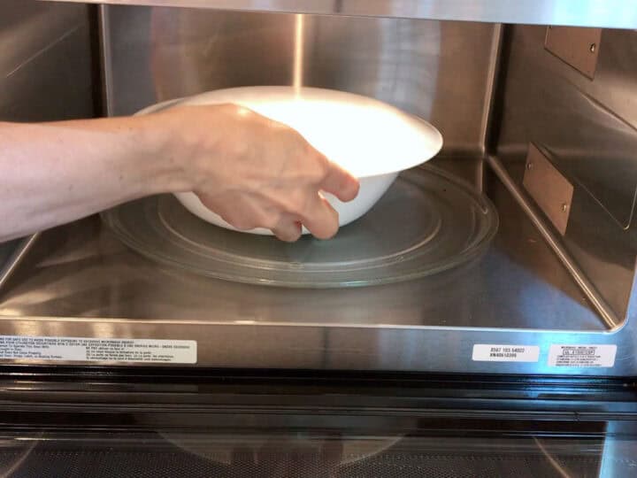 Placing the bowl in the microwave.