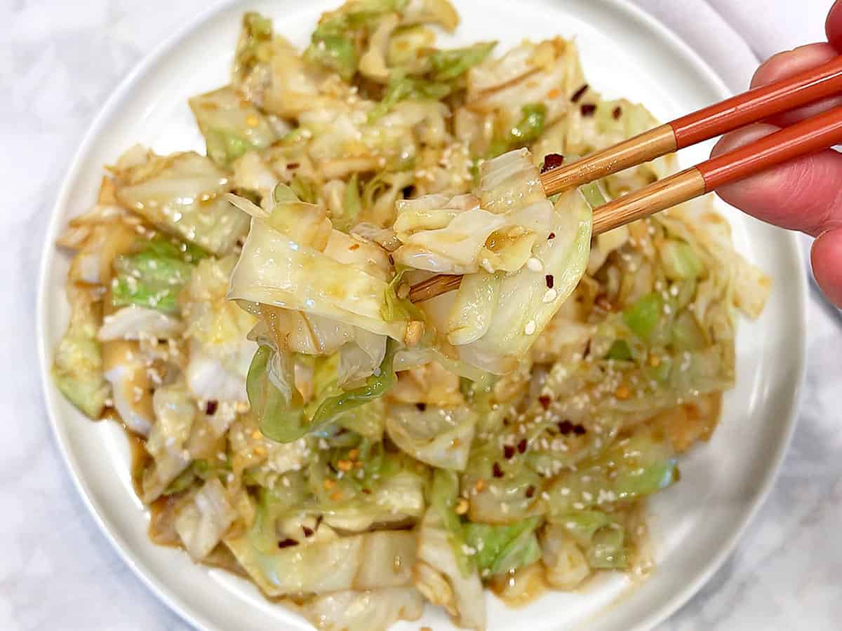 Cabbage stir fry is served with chopsticks.