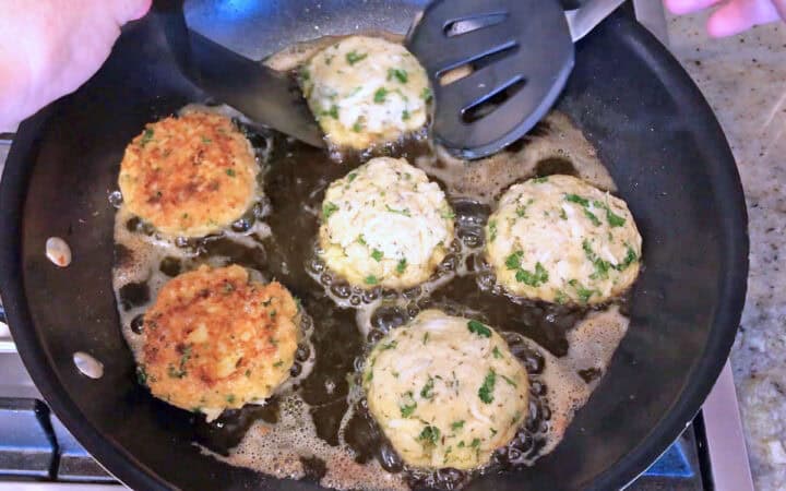 Flipping a crab cake in the skillet.