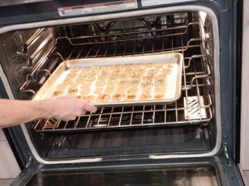 Placing the crackers in the oven.
