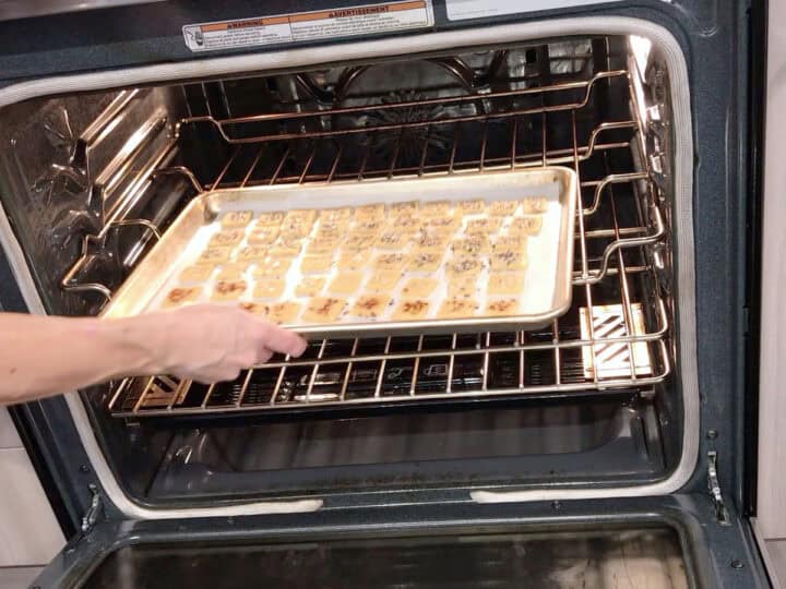Placing the crackers in the oven.