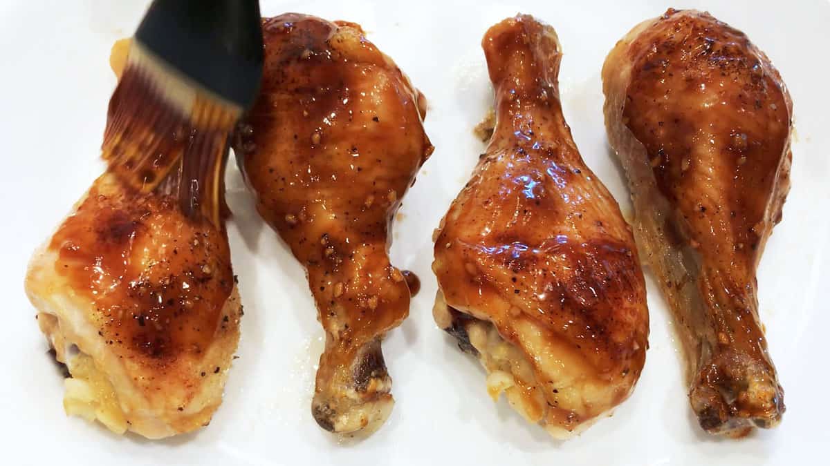 Brushing the chicken with the glaze.