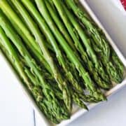Microwave asparagus is served on a white platter.