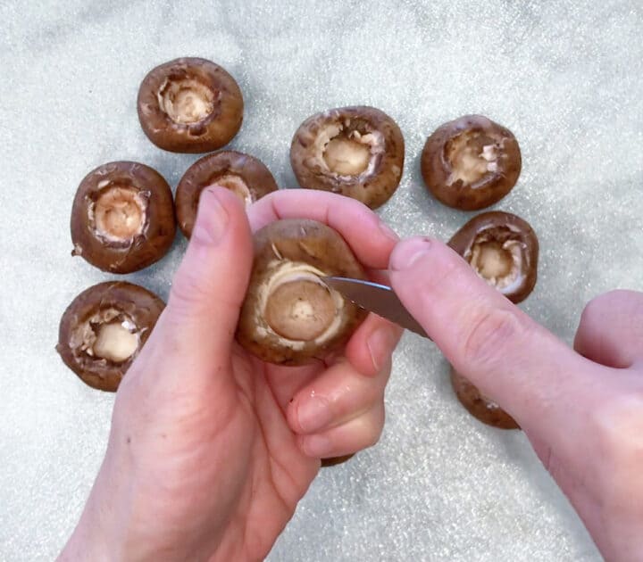 Prepping the mushrooms by removing the stems.