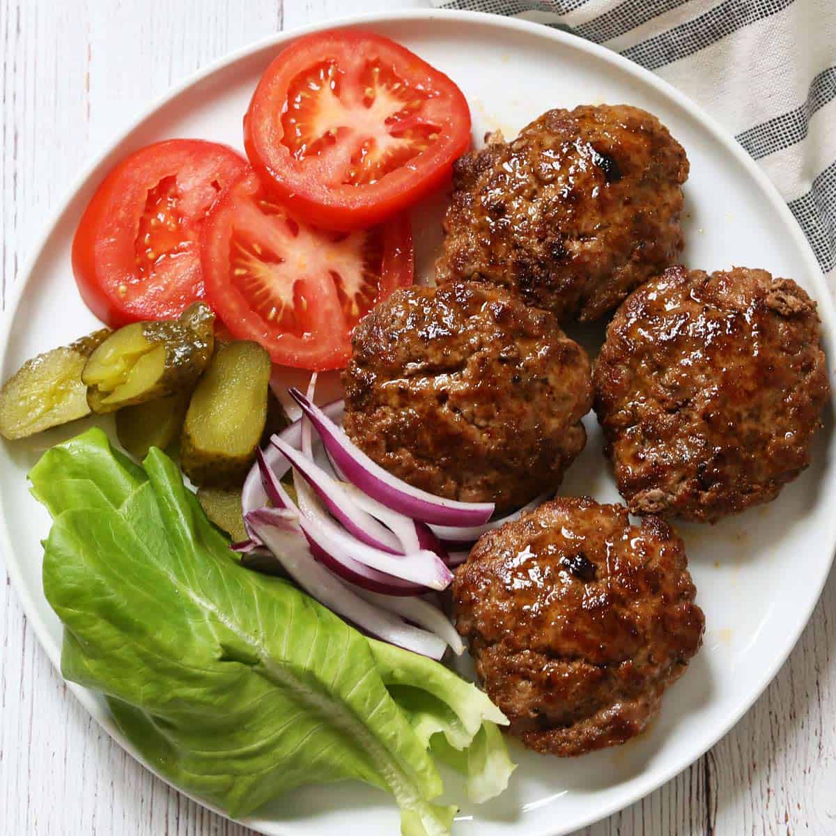 Puffy pork burgers on a plate.