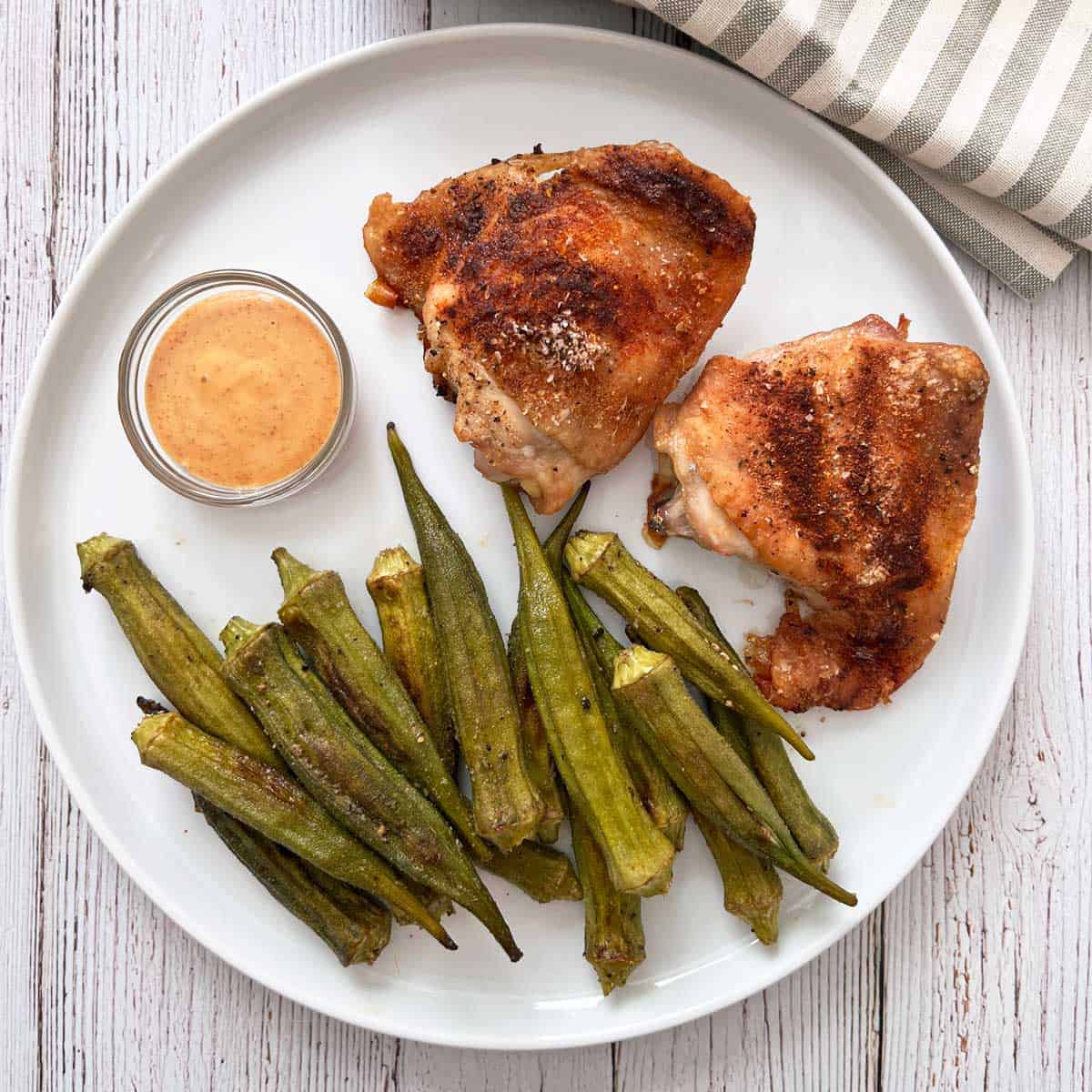 Roasted okra is served with chicken thighs.