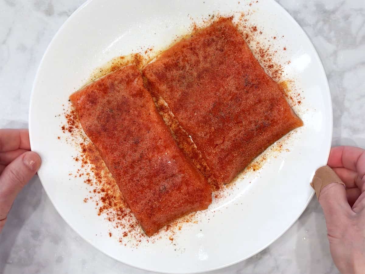 Seasoned salmon pieces on a plate.