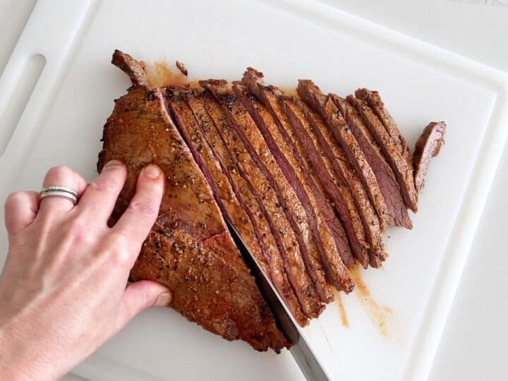 Slicing the steak with a chef's knife.