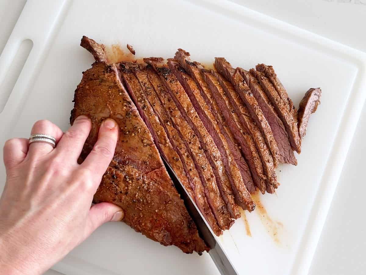 Slicing the steak with a chef's knife.
