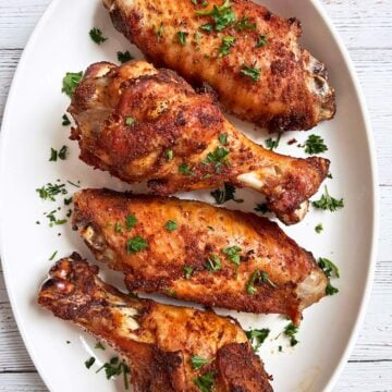 Baked turkey wings are served on a white platter.