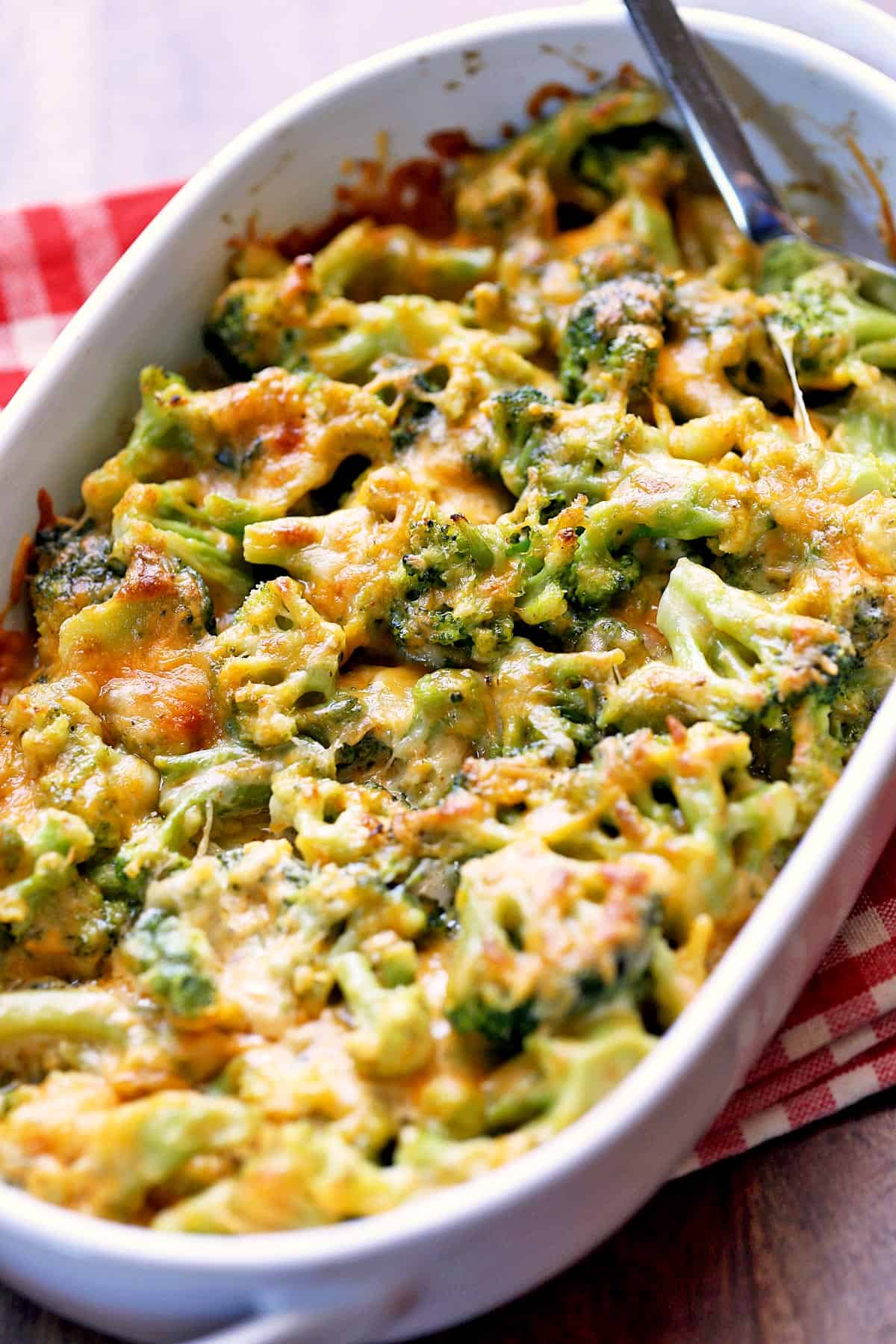 Broccoli cheese casserole is served in a white baking dish.