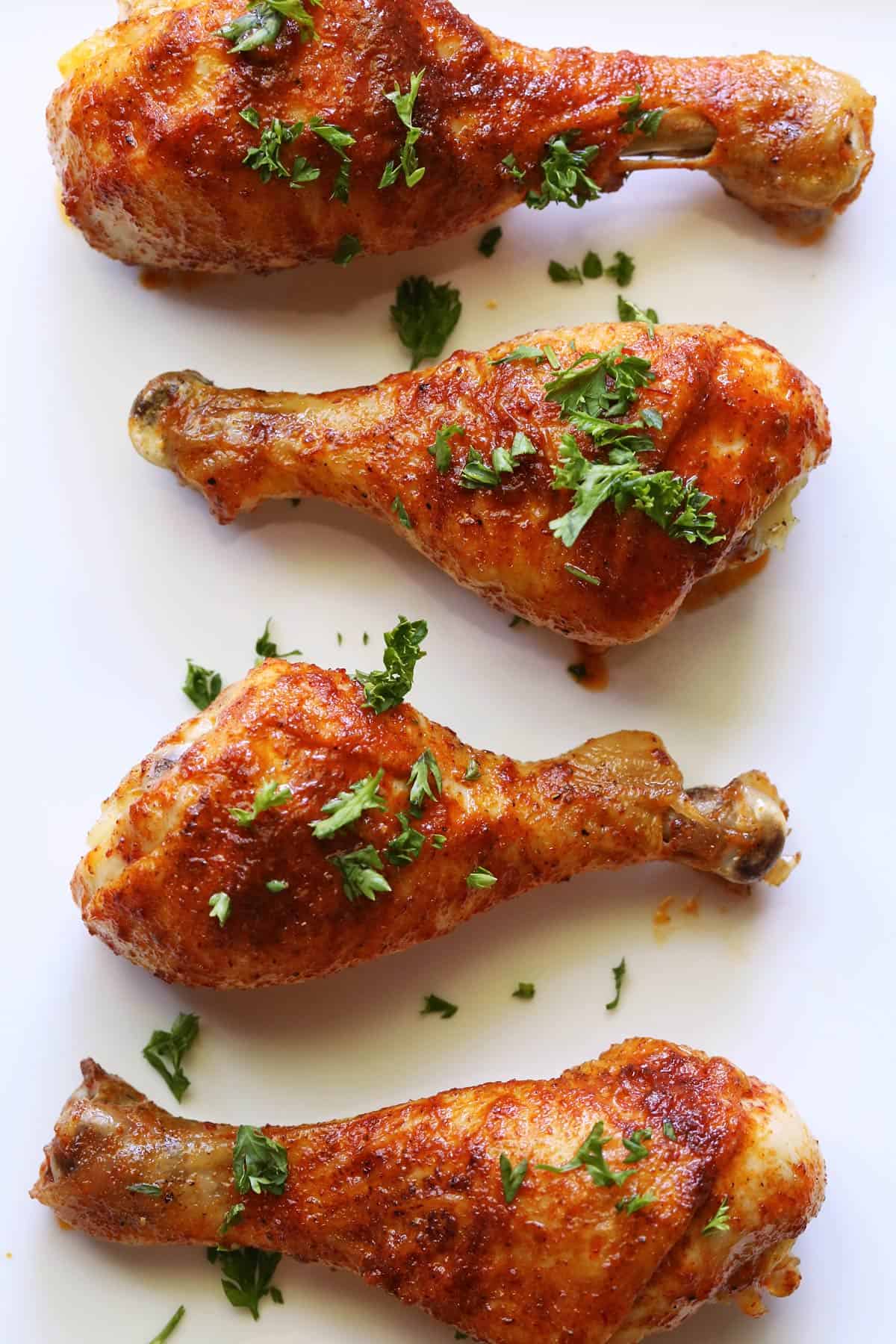 Four buffalo drumsticks are served on a white platter.