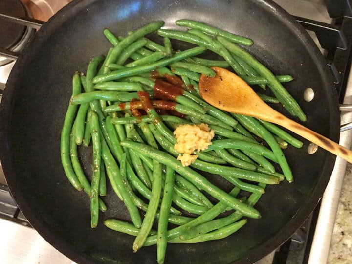 Adding hot sauce, garlic, and honey.