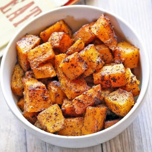 Roasted butternut squash is served in a white bowl.