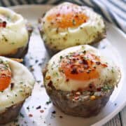 Sausage egg muffins are served on a white plate.