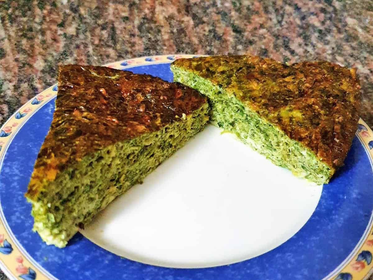 Two slices of a crustless spinach quiche on a plate.