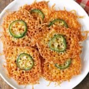 Cheese crisps are piled on a plate.