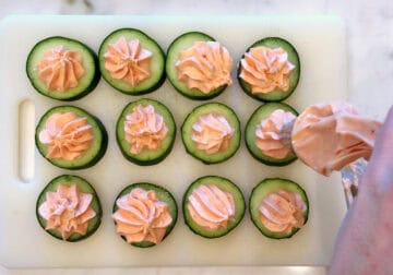 Piping the mousse onto the cucumber slices.