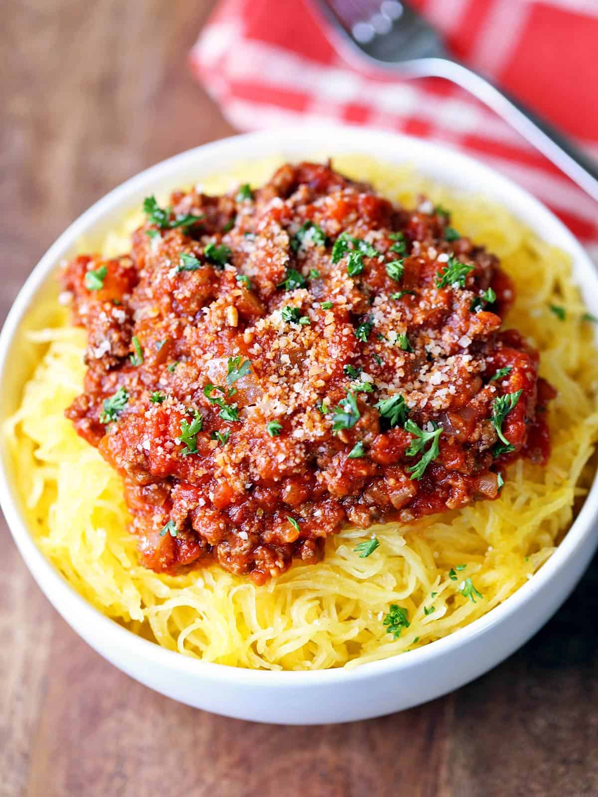 Spaghetti squash with meat sauce is served in a white bowl.