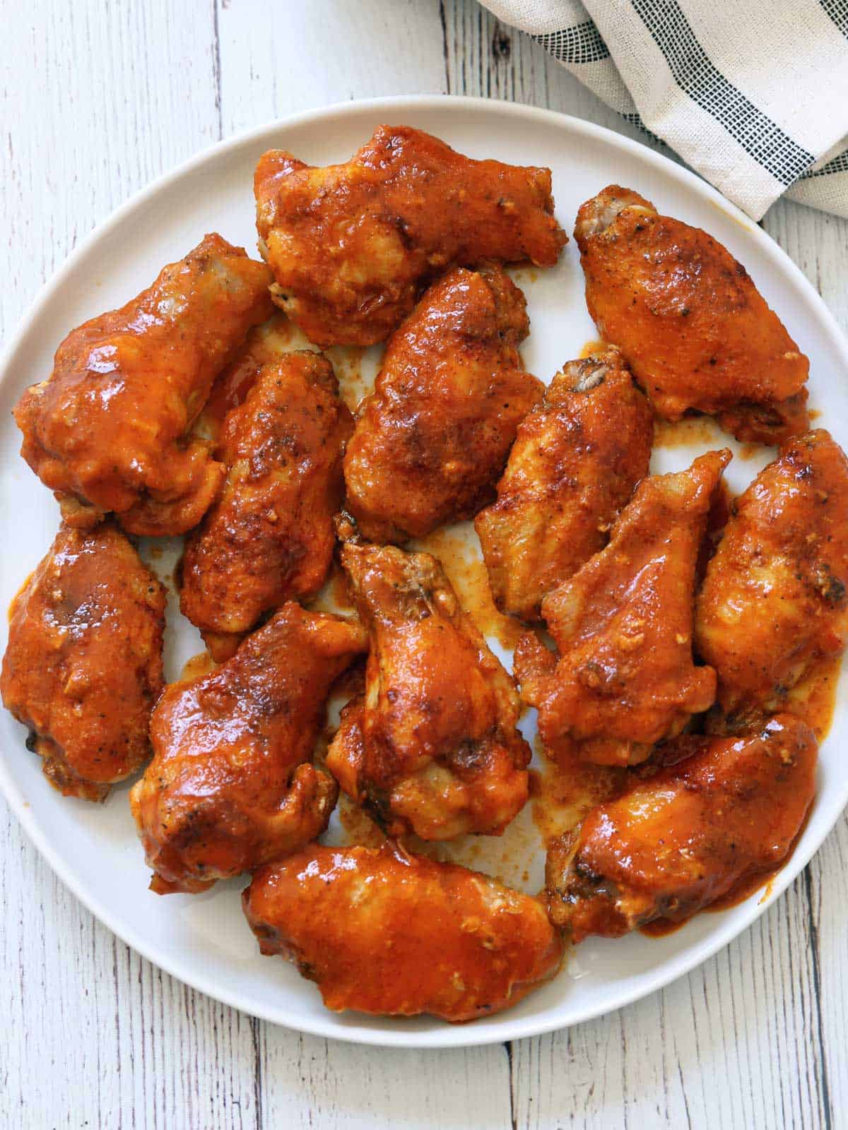 Buffalo wings are served on a white plate.