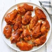 Buffalo wings are served on a white plate.