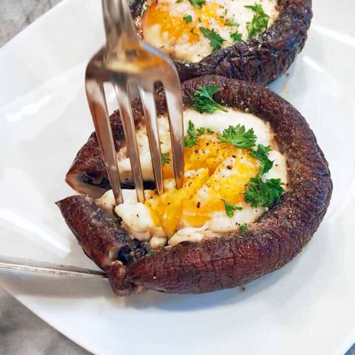 Cutting into a mushroom with a fork and a knife.