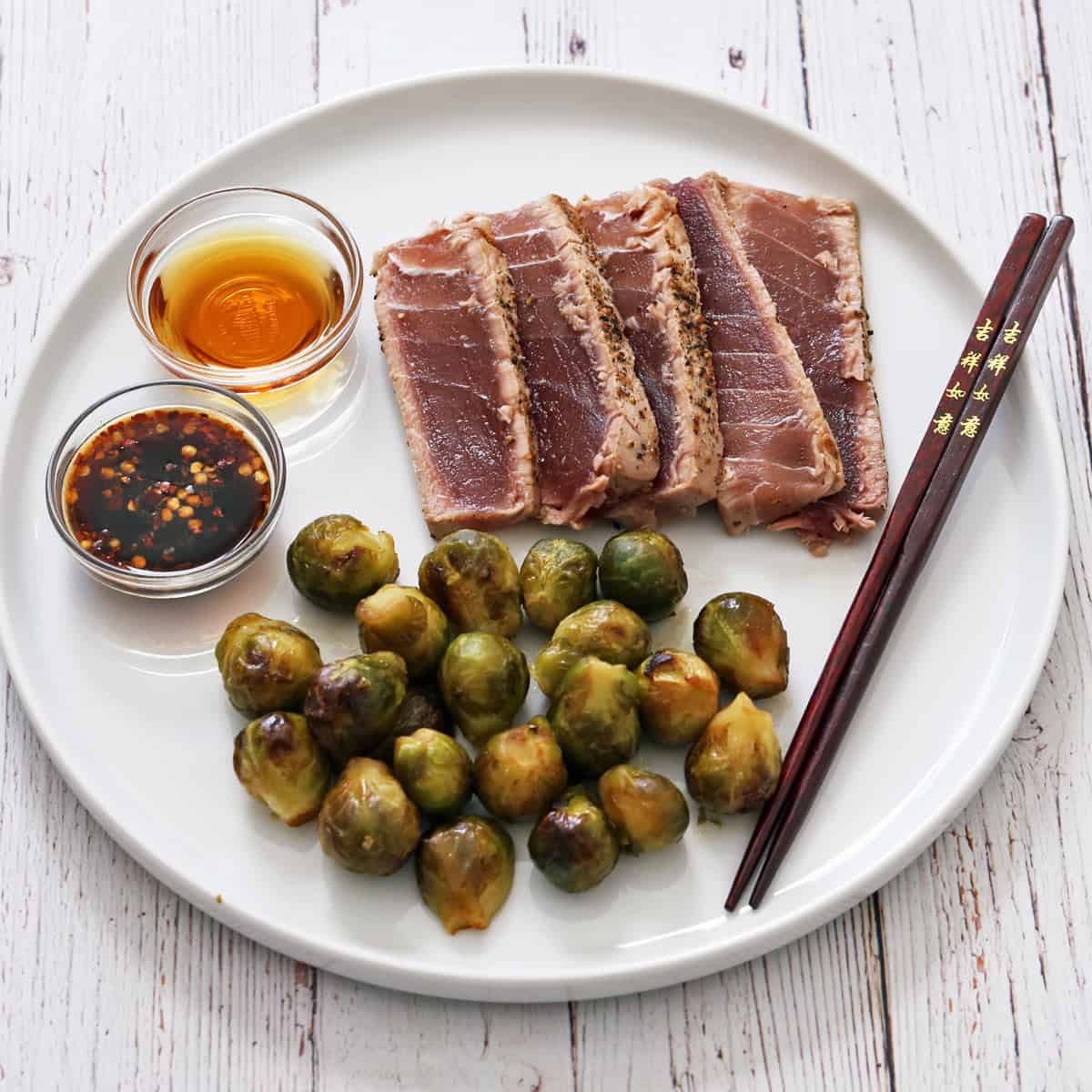 Seared tuna steak is served with Brussels sprouts.
