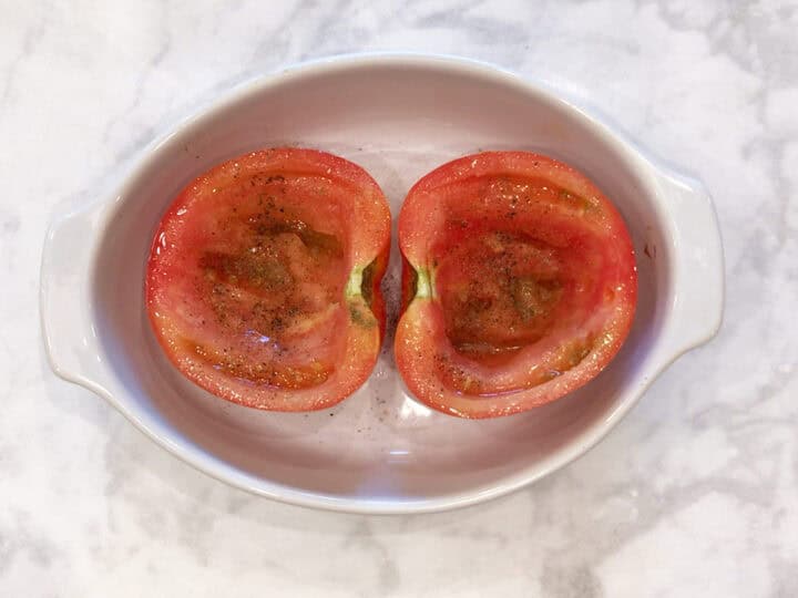 Oiled and seasoned tomatoes in the baking dish.