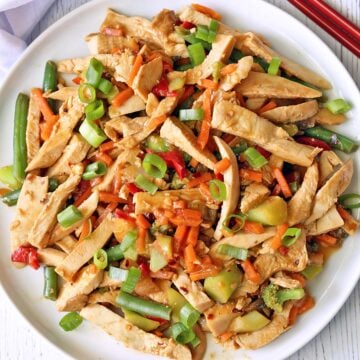 Turkey stir fry is served on a white plate.