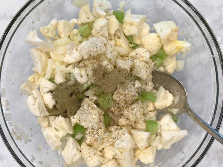 Veggies, melted butter, and spices in a bowl.