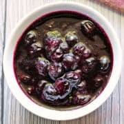 Blueberry compote is served in a white bowl.