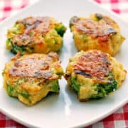 Four broccoli tots are served on a white plate.