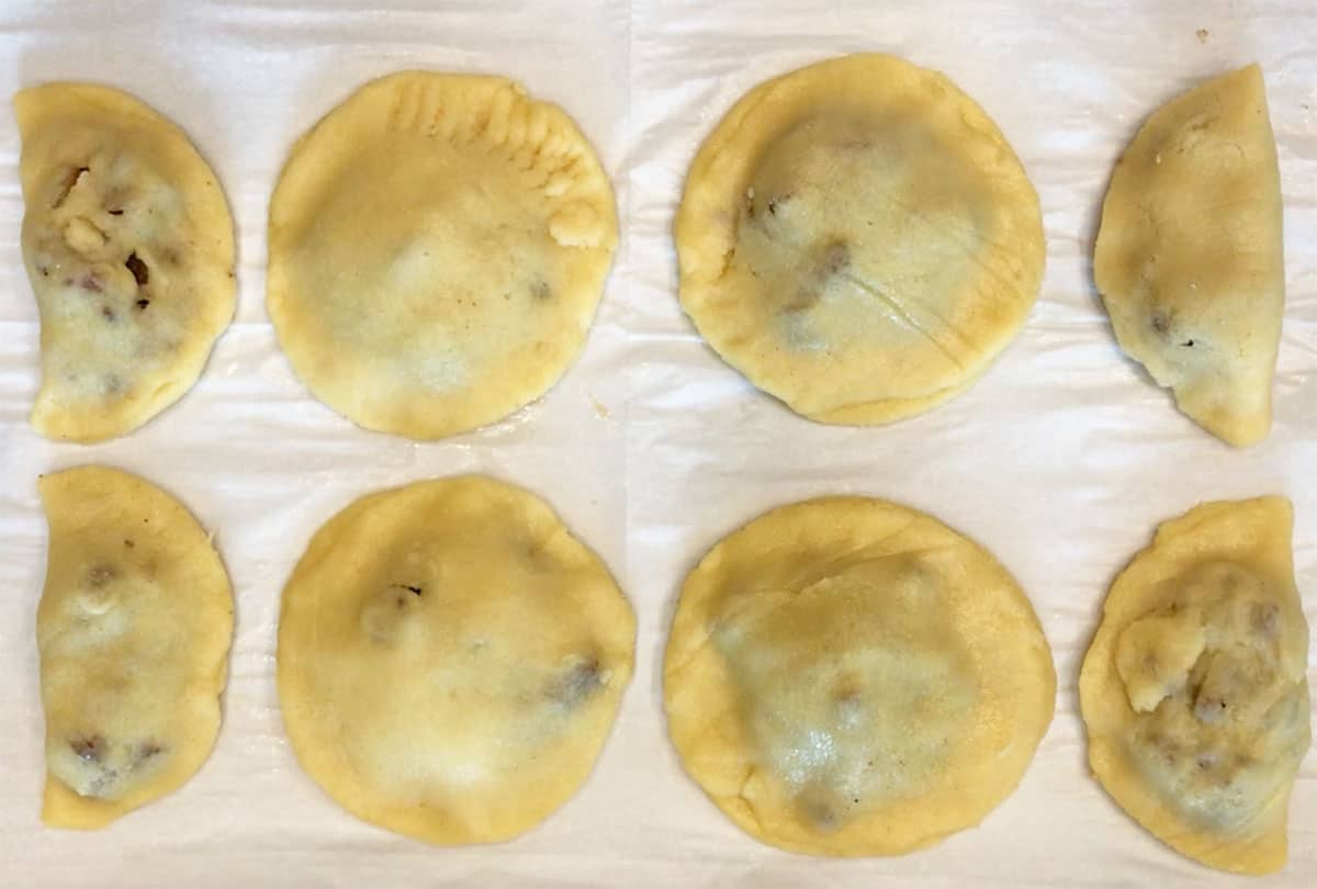Different empanada shapes on the pan.